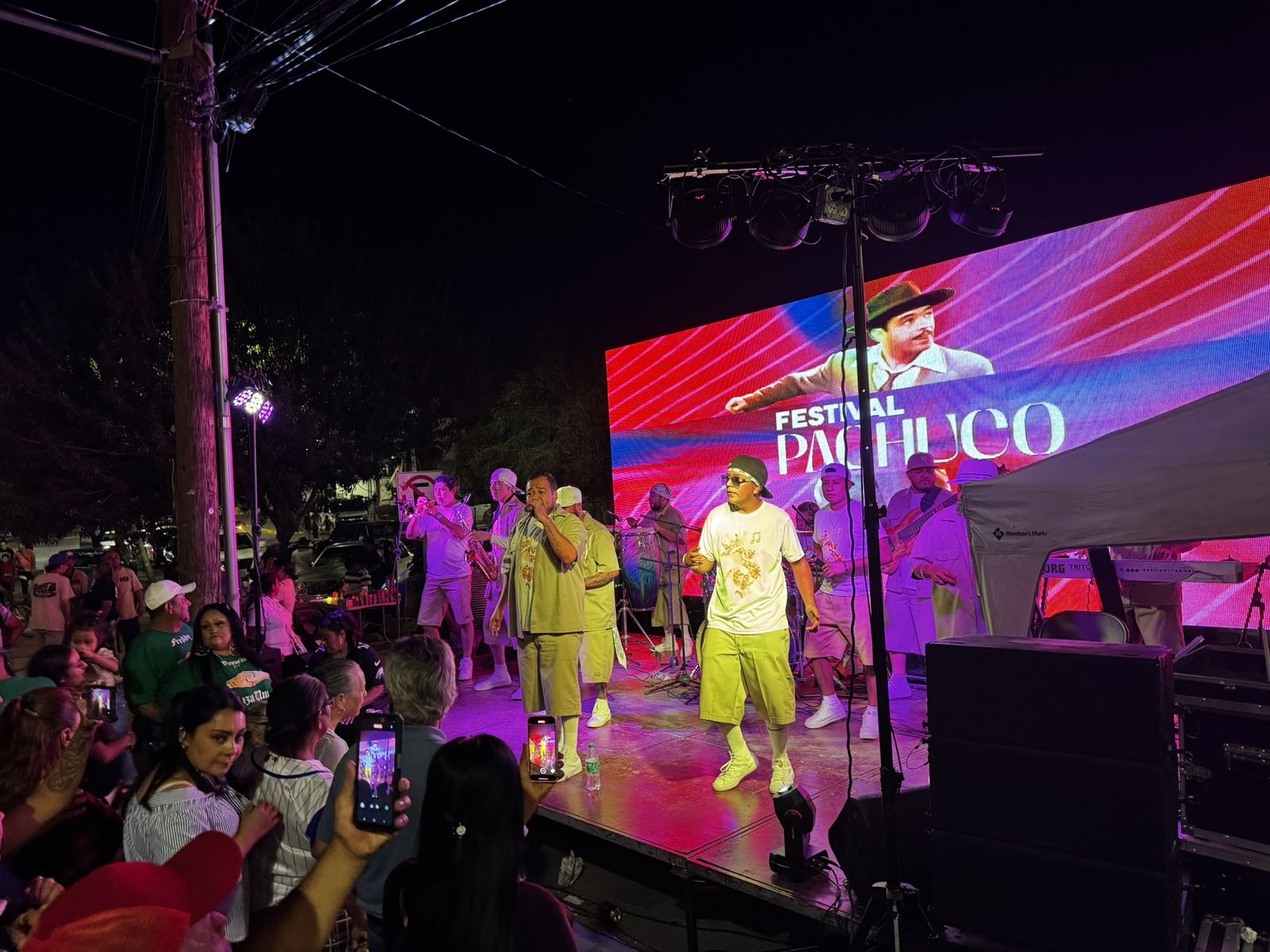 Festival nocturno con escenario, pantalla LED y público